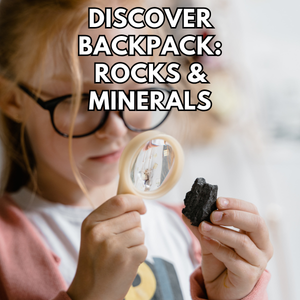 child inspecting a rock with magnifying glass