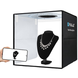 light box with a mannequin displaying a necklace inside, someone taking a photo