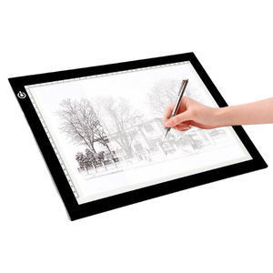 person drawing on tracing light box