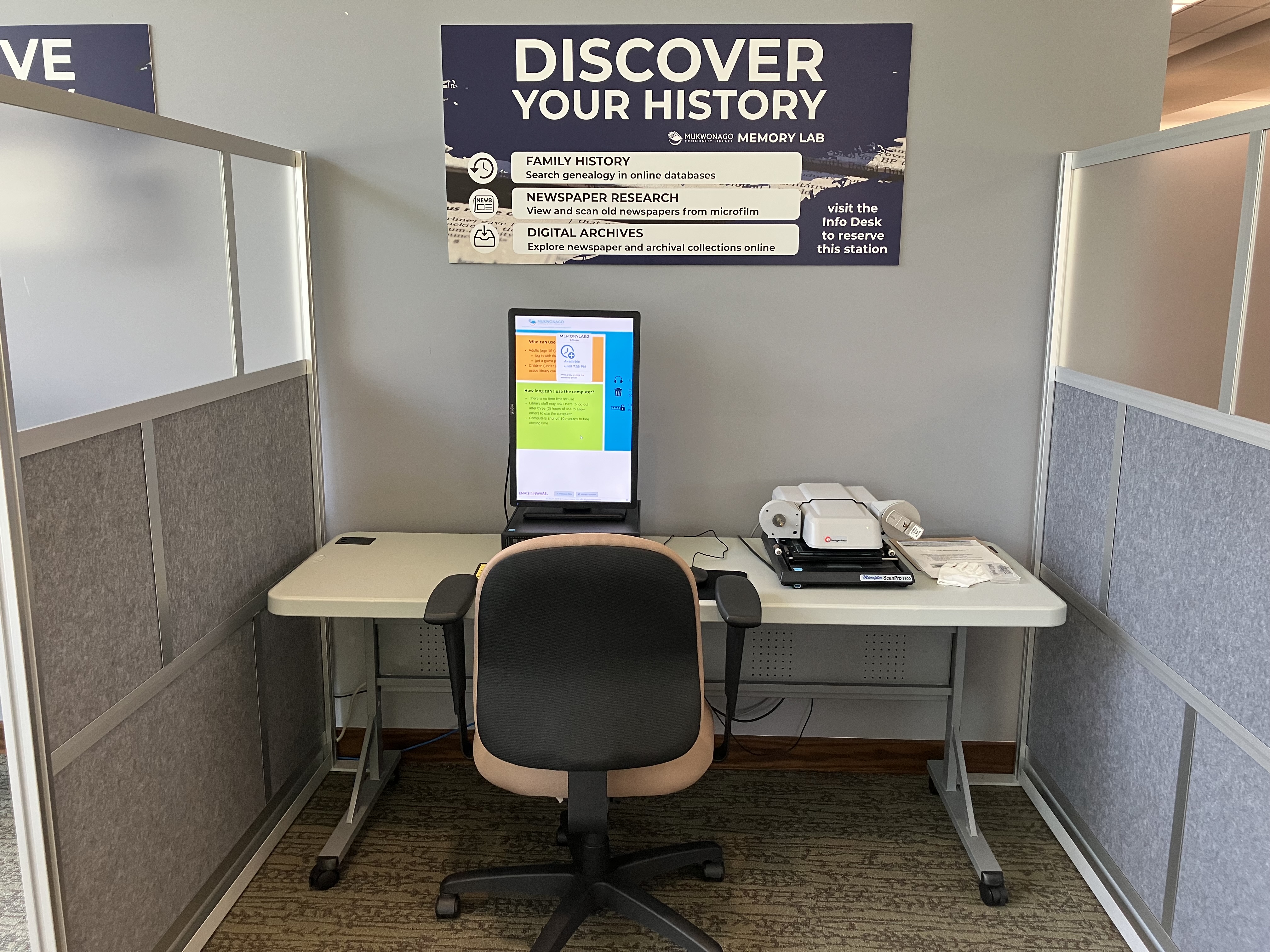 Memory Lab with sign reading "Discover Your History" and microfilm reader on desk
