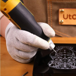 person engraving pattern on to metal sheet