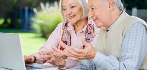 Photo of senior citizens looking at a computer 