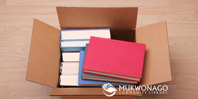 Image depicts an open cardboard box full of new books. Mukwonago Community Library Watermark is applied. 