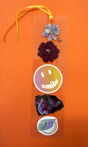 laminated bookmark with flowers, smiley face sticker, picture of stuffed unicorn, coloring picture of books