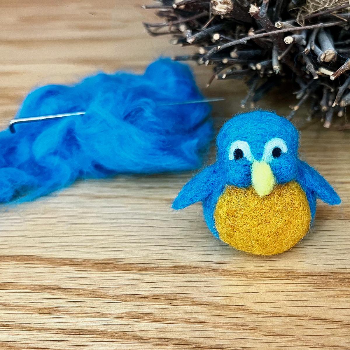 blue wool roving with a small needle felted bluebird