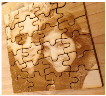 wood with laser engraved photo of people smiling and cut lines for a puzzle